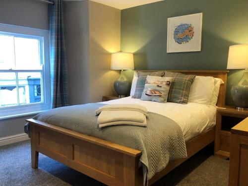 帕兹托伦敦旅馆的一间卧室配有一张带两盏灯的床和一扇窗户。