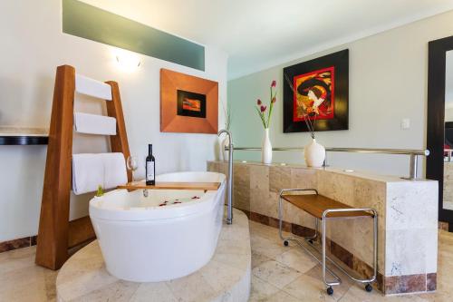 莱昂瑞奥米娜斯薄路瑞木酒店的一间带大浴缸和水槽的浴室