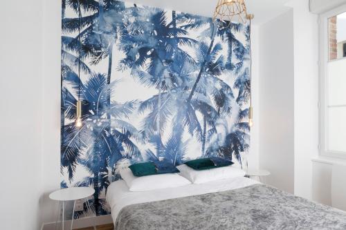 拉瓦勒Résidence Solférino的一间拥有蓝棕榈树壁画的卧室