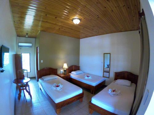 CanoasHotel Los Higuerones的一间设有两张床和一张桌子的房间
