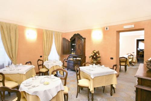 卡鲁帕拉索迪梅佐酒店的餐厅配有桌椅和白色桌布