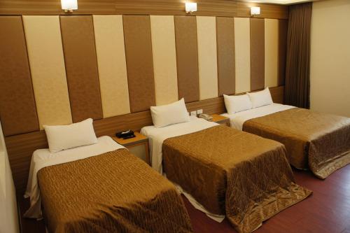 Mailiao巴黎汽车旅馆的一间设有三张床和条纹墙的房间