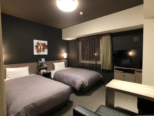 常滑市常滑站前路线酒店的酒店客房设有两张床和电视。