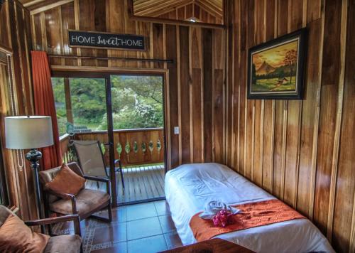 蒙泰韦尔德哥斯达黎加Cabañas Hoja Verde的卧室配有一张床和一个阅读家常夜曲的标志