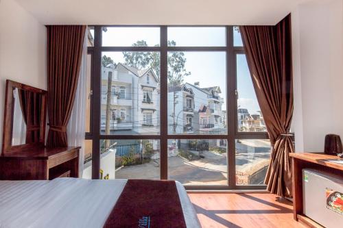 大叻Villa Bảo Anh Dalat的卧室设有大窗户,享有街道的景色