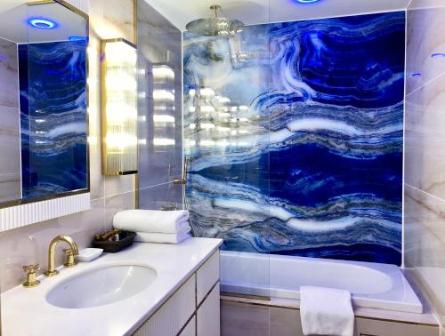 伊斯坦布尔Hotel Zurich Istanbul Old City的一间带水槽和蓝色淋浴的浴室