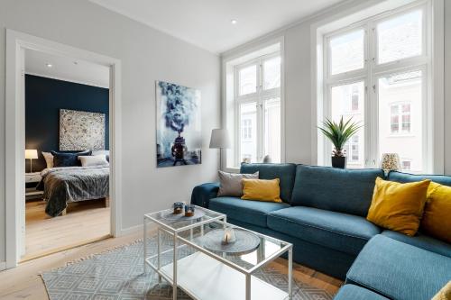 卑尔根Høyden Apartments的客厅配有蓝色的沙发和床。