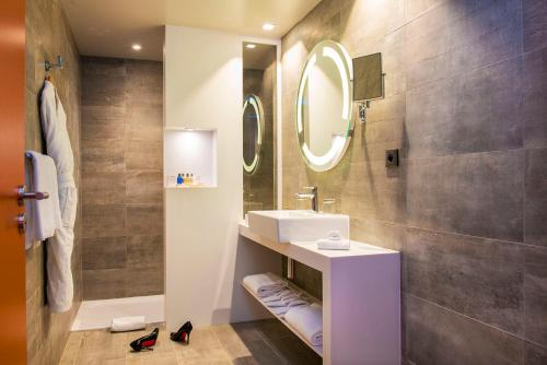 波尔多Radisson Blu Hotel Bordeaux的一间带水槽和镜子的浴室