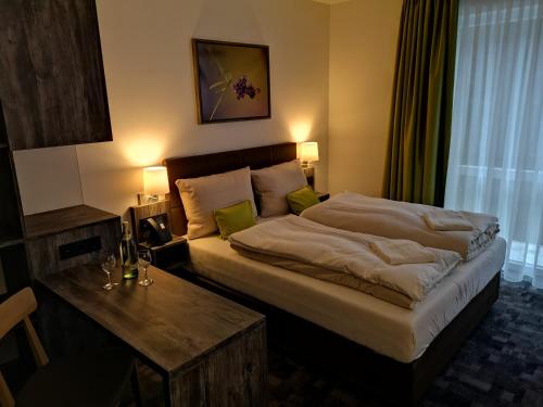 哈雷威斯特法伦Hotel Grünwalde的酒店客房设有一张大床和一张桌子。