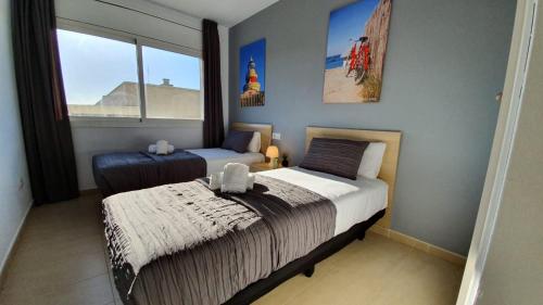萨洛Salou Med Apartamentos的一间卧室设有两张床和窗户。