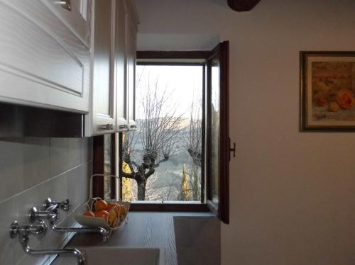 蒙特普齐亚诺CASA SERENA的厨房设有窗户和水槽,享有美景。