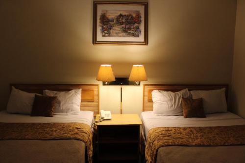 圣萨尔瓦多地中海广场酒店的配有2盏灯的酒店客房的2张床