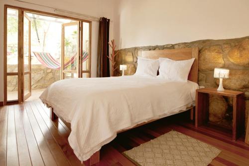 CarazCasa Pukayaku Lodge的一间卧室设有一张大床和一个大窗户