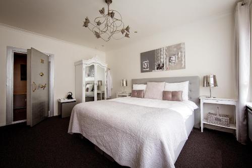 奥斯特豪特BBB别墅的白色卧室配有一张大床和吊灯