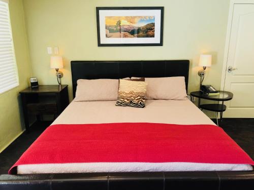 奥克赫斯特河畔皇后酒店的一间卧室配有一张带红色毯子的大床