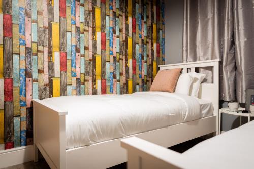 曼彻斯特REM酒店的卧室配有白色的床和色彩缤纷的墙壁