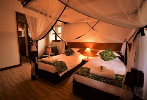 恩德培Elementis Entebbe的一间帐篷内带两张床的卧室