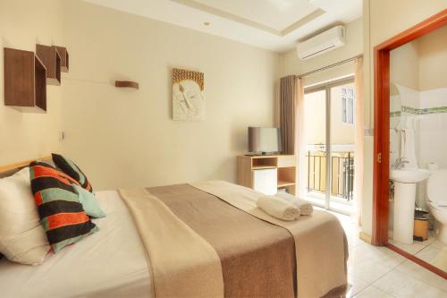 弗利康弗拉克海之洋旅行公寓式酒店的一间卧室配有一张床,浴室设有窗户