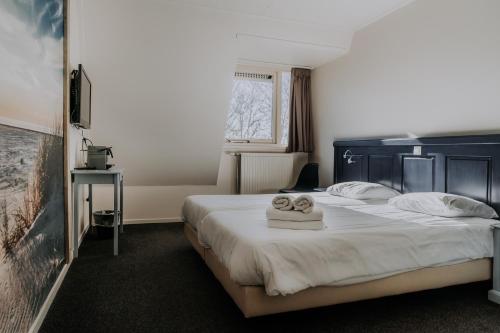 斯希蒙尼克奥赫Hotel De4dames的酒店客房,配有带毛巾的床