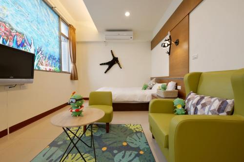 马公沿菊文旅的一间配备有沙发、床和电视的客房