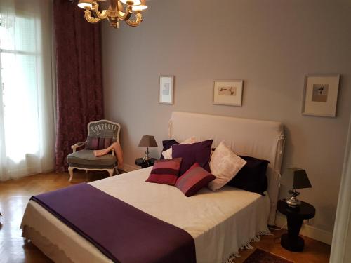 尼斯Capitole Bleu的一间卧室配有带枕头和椅子的床