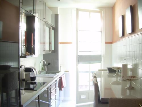 尼斯Capitole Bleu的厨房配有柜台、水槽和窗户