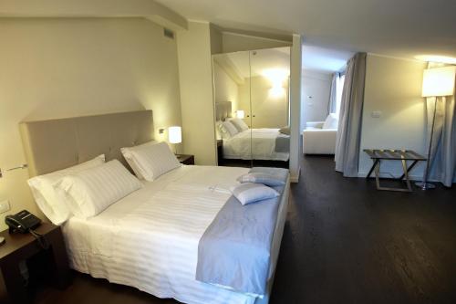拉奎拉迪莫拉德尔巴索酒店的卧室配有一张白色大床和镜子