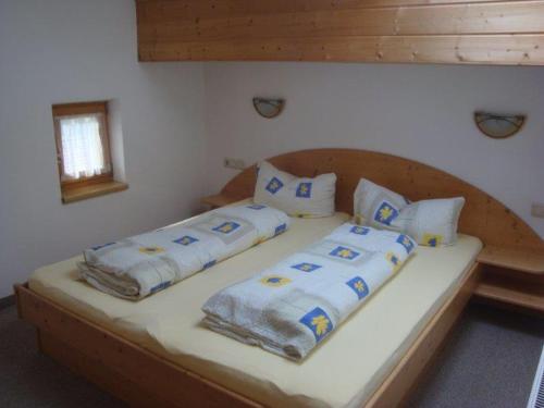 施图拜河谷新施蒂夫特Alpenhaus Christian的卧室内的一张带四个枕头的床