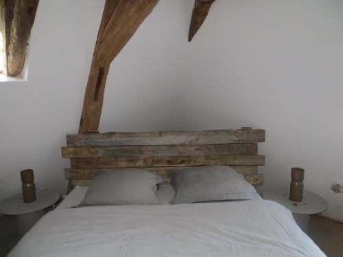 Lamonzie-MontastrucLes jardins de Peychenval的一间卧室配有木制床头板和白色的床