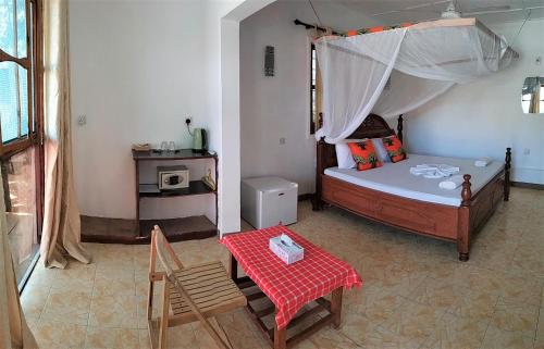 肯杜瓦莫克海滩别墅旅馆的卧室配有一张床和一张桌子及椅子