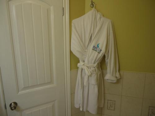 金斯顿碧沙酒店及滨海套房的浴室的门上挂着一件长袍