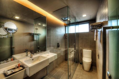 哥打京那巴鲁Raia Hotel Kota Kinabalu的一间带水槽、卫生间和镜子的浴室