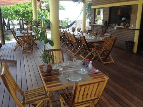 普拉亚德莫伊塔斯Pousada Lacula的木甲板上设有桌椅的餐厅