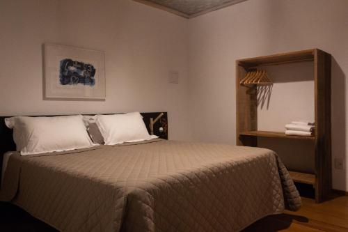 圣安娜杜里亚舒Pousada Villa Madorna的一间卧室配有一张带白色枕头和镜子的床