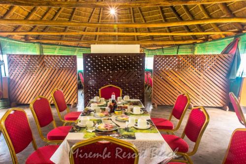 KalangalaMirembe Resort Beach Hotel Ssese的墙上的桌子和红色椅子