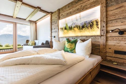 罗登戈Ahner Berghof的一间卧室设有一张带木墙的大床