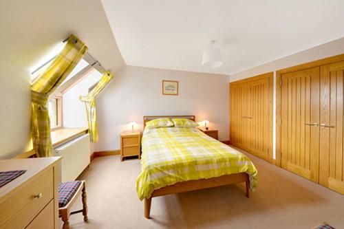 戈尔布里奇The Arches, Borthwick Mains Farm,的一间卧室设有黄色的床和窗户。