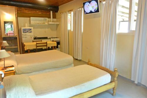 圣拉斐尔Cabañas Las Marias的一间卧室配有两张床和一张桌子及一台电视机