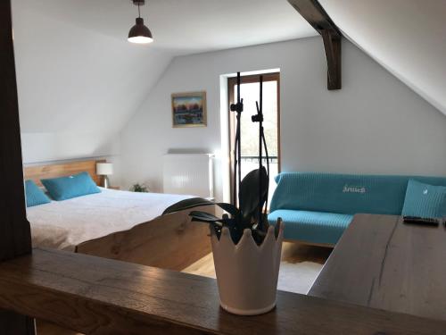 ŠtoreTourist farm Artisek的一间卧室配有一张床和一张带盆栽的桌子