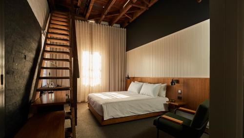 KatanningThe Premier Mill Hotel的一间卧室设有一张床和一个螺旋楼梯