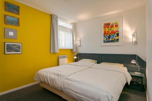 赫劳Quo Vadis的一间卧室设有一张床和黄色的墙壁