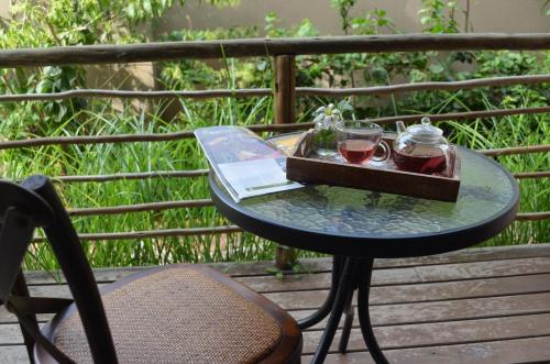 马普托Acacia Inn GuestHouse的阳台上的桌子和两杯葡萄酒