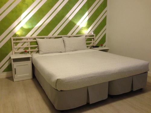 特伦托B&B Homer Trento的绿色墙壁的房间里一张白色的床