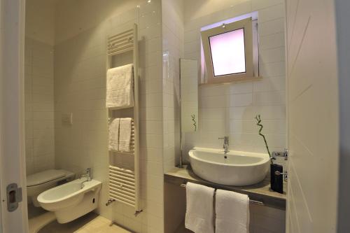 安德里亚Foresteria Pellegrino的白色的浴室设有水槽和卫生间。