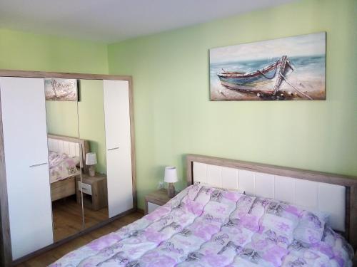 布尔加斯Tvardica Apartment的卧室配有一张床,墙上挂有绘画作品