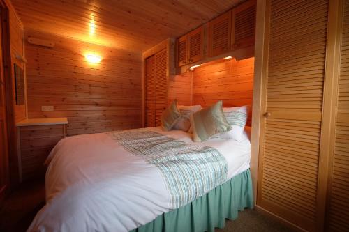 凯西克Fellside Lodge的卧室配有白色的木墙床