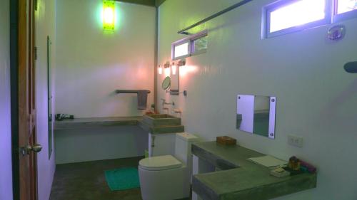 曼巴豪在别处精品度假酒店的一间带水槽、卫生间和镜子的浴室