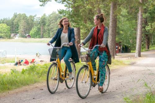 HasselöHasselö Hostel的两辆女子骑车在湖边的小径上