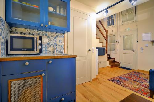 约阿尼纳古风酒店的厨房配有蓝色橱柜和微波炉