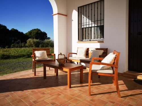 厄尔-汝姆披多Casa Rural Cerca de la Playa El Rompido的庭院里摆放着一组椅子和一张桌子